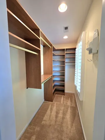 a view of walk in closet with empty racks