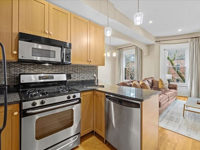 a kitchen with stainless steel appliances granite countertop a stove microwave and sink