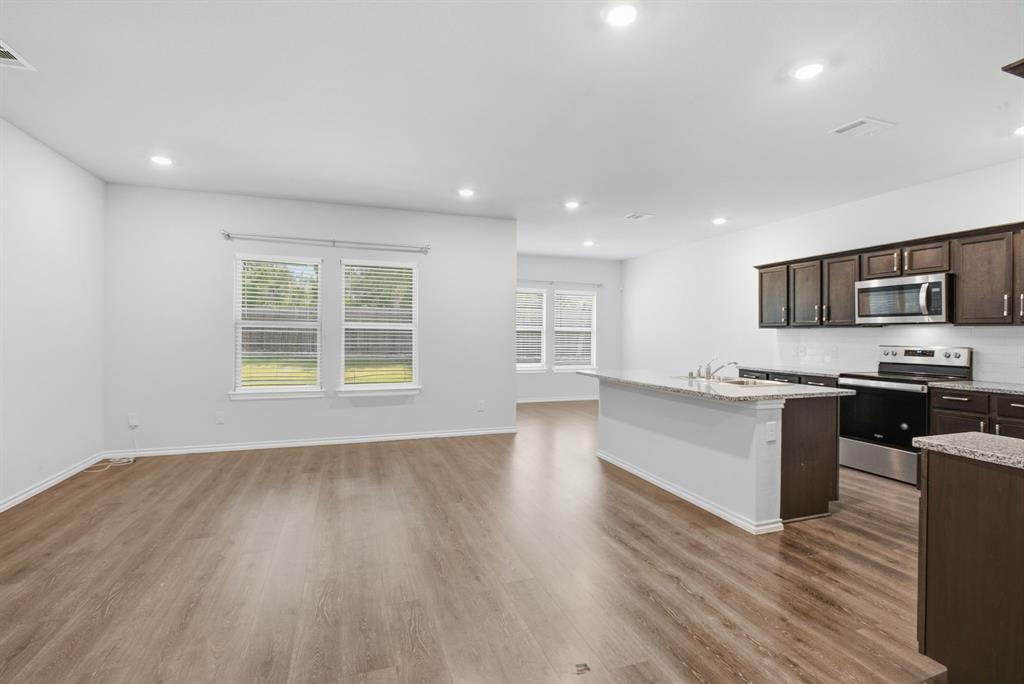 1328 Broaddus Road Forney, TX 75126 - Photo 10 of 31 Open-concept living space featuring wood-finish flooring, recessed lighting, and white walls