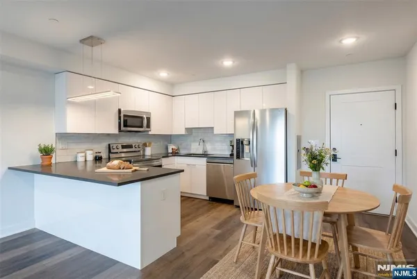 a kitchen with white cabinets and stainless steel appliances