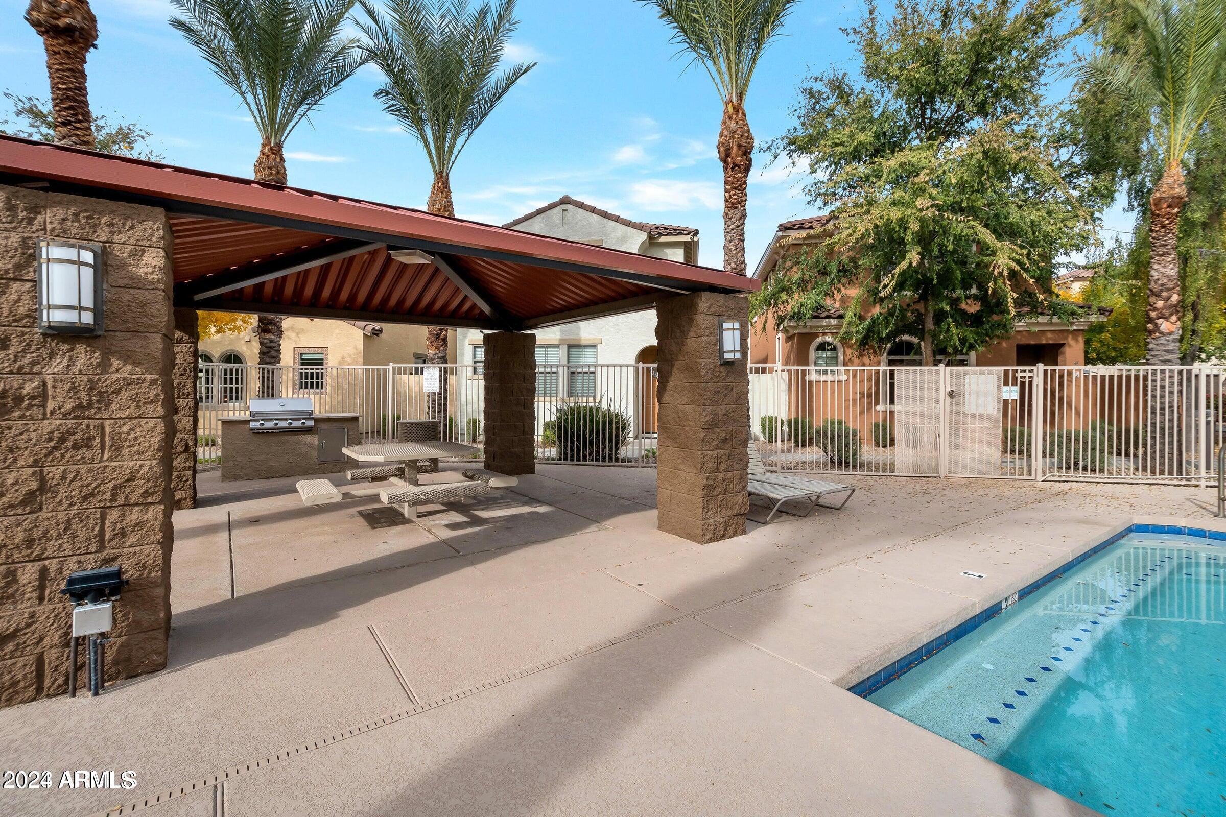 451 South Hawes Road, Unit 68 Mesa, AZ 85208 - Photo 24 of 30 a view of a patio with a table and chairs under an umbrella