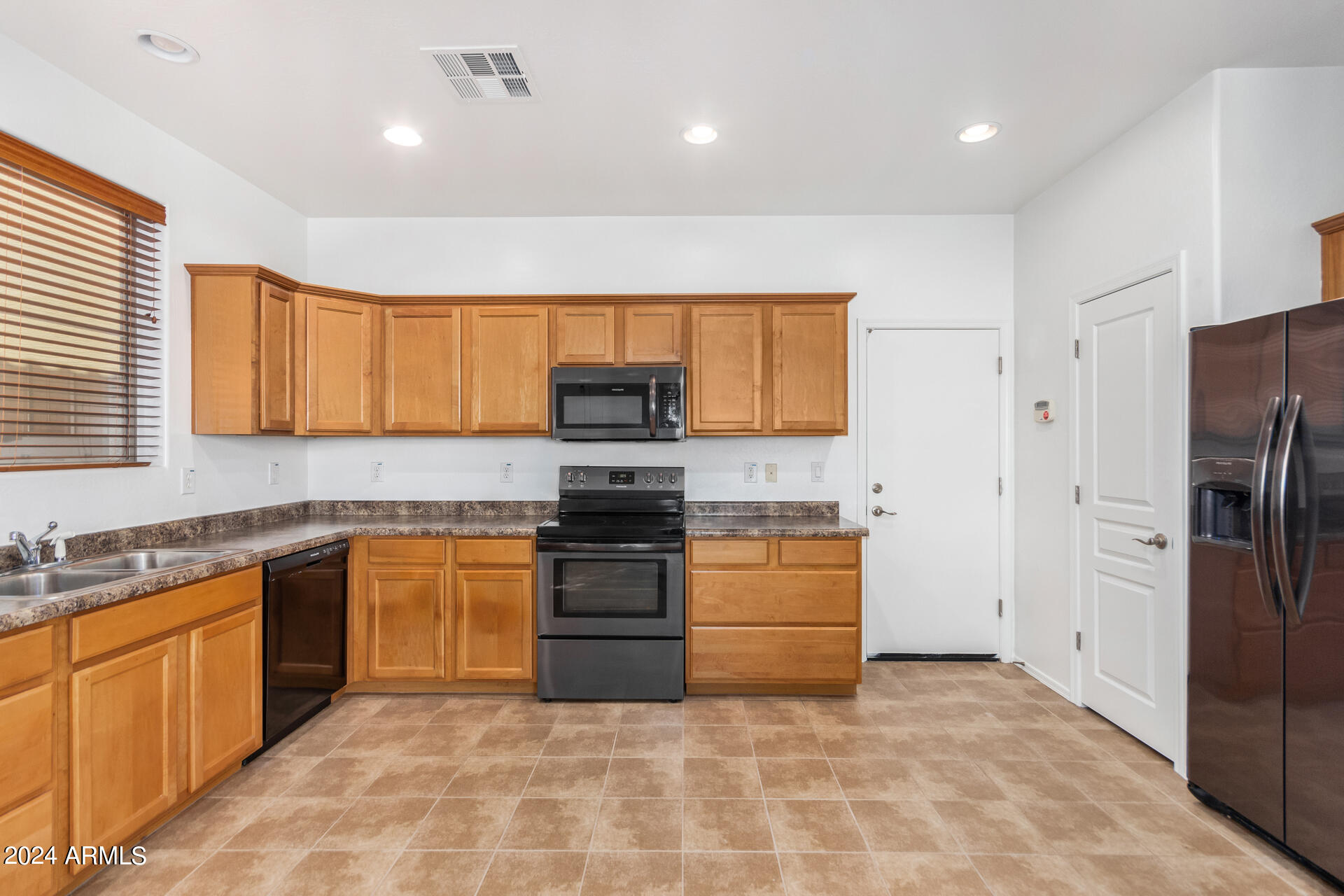 451 South Hawes Road, Unit 68 Mesa, AZ 85208 - Photo 6 of 30 a kitchen with stainless steel appliances granite countertop a stove top oven a sink and dishwasher a refrigerator with wooden cabinets