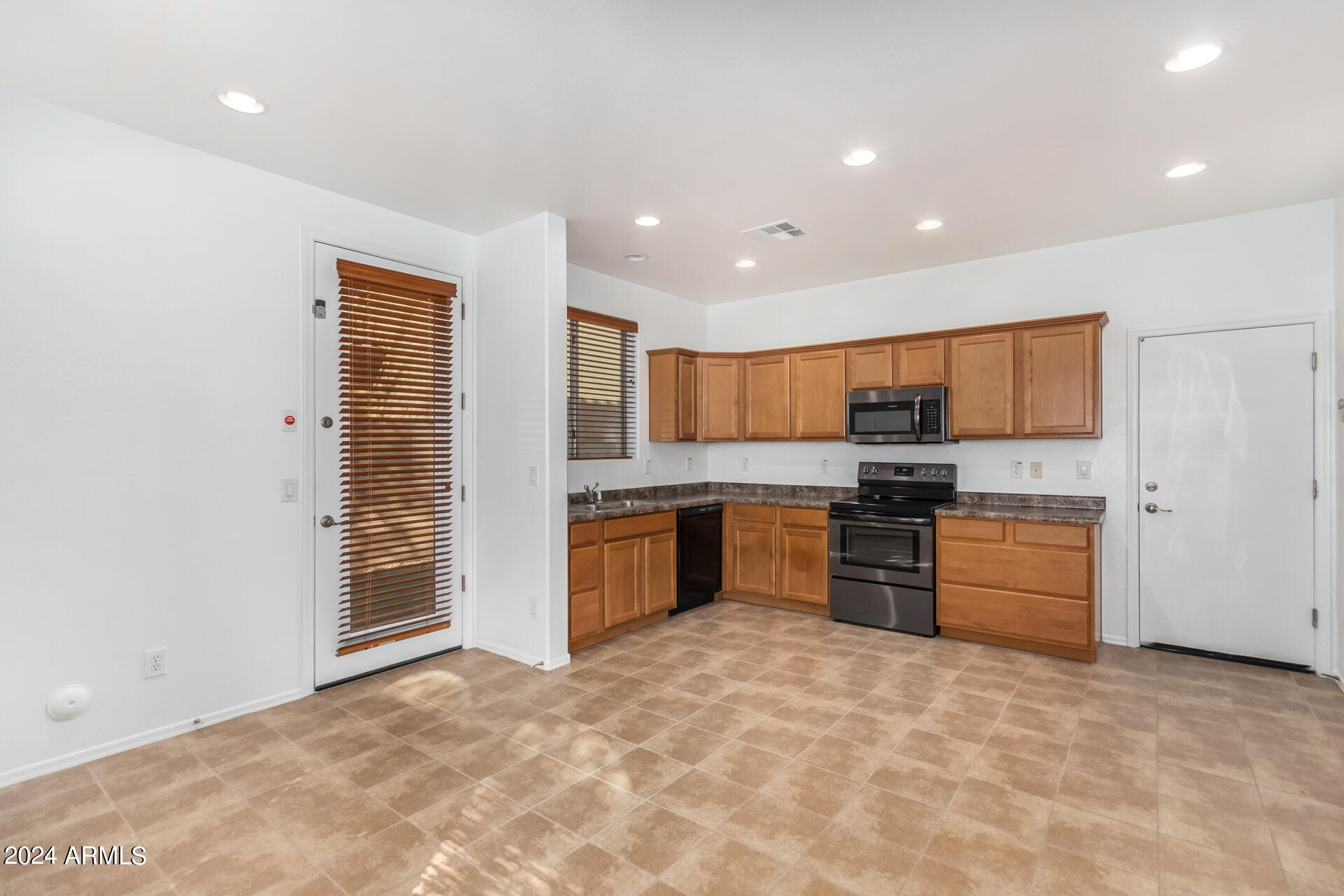 451 South Hawes Road, Unit 68 Mesa, AZ 85208 - Photo 8 of 30 a large kitchen with stainless steel appliances a refrigerator and a stove top oven