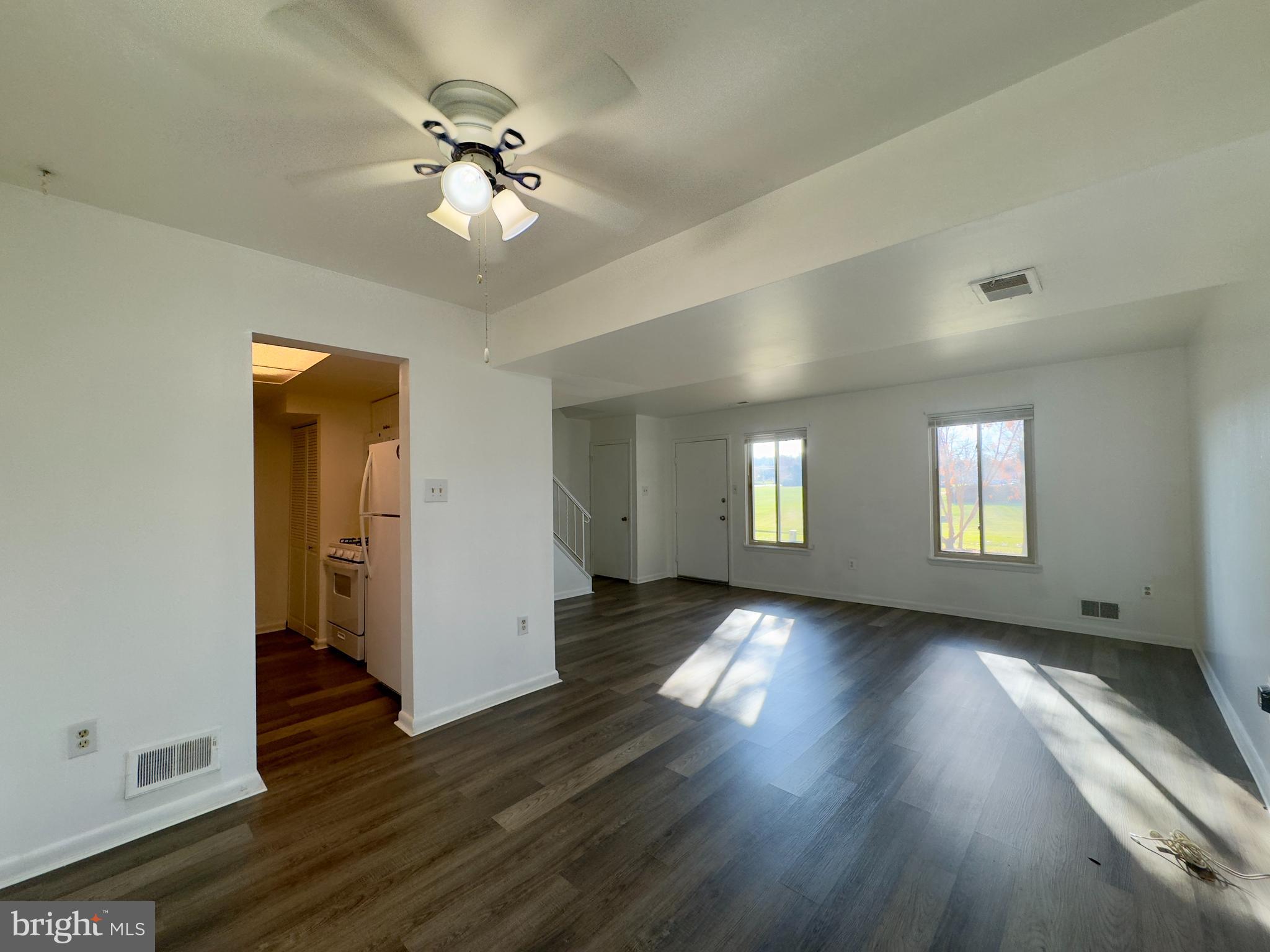 8 King Henry Circle Baltimore, MD 21237 - Photo 3 of 10 a view of an empty room with wooden floor and a window