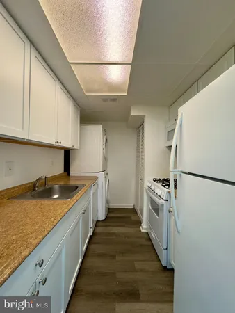 a kitchen with granite countertop a sink a counter space and stainless steel appliances