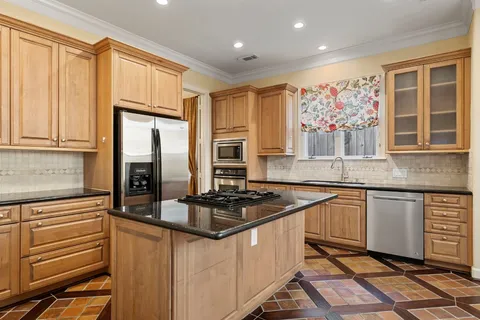 a kitchen with stainless steel appliances granite countertop a stove a sink and a microwave