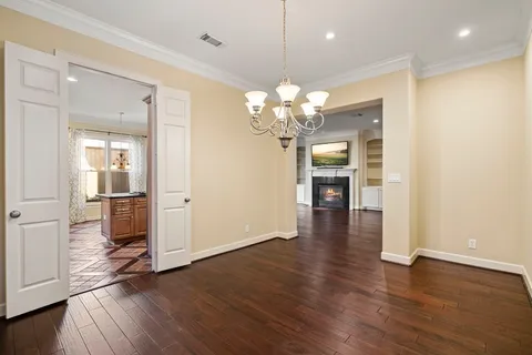 a view of a room with wooden floor and kitchen view