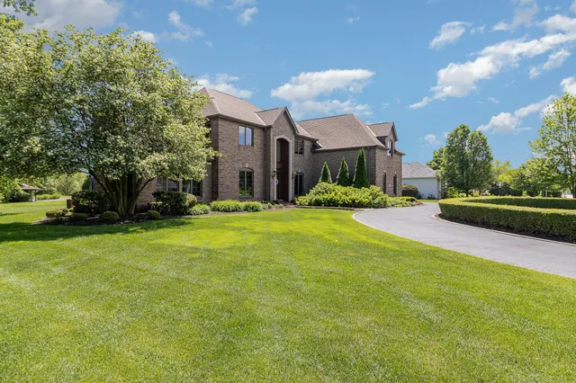 a view of a house with a big yard and large trees