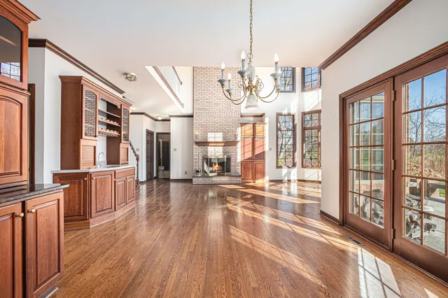a view of a living room with wooden floor and floor to ceiling windows