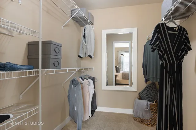 a view of walk in closet with clothes and shoes