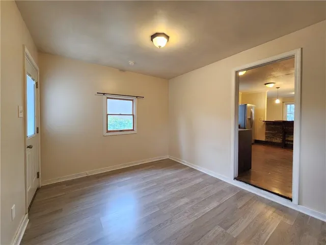 an empty room with wooden floor and mirror