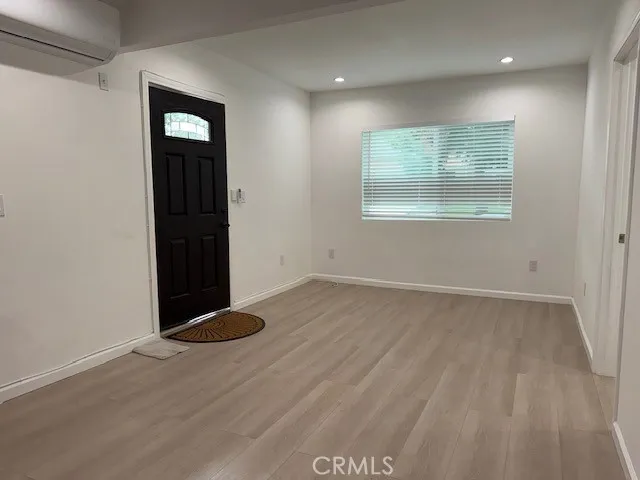 a view of a small space with wooden floor and a window