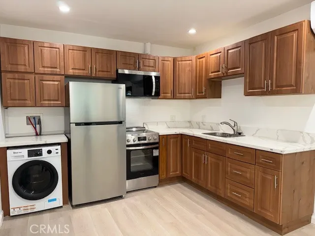 a kitchen with stainless steel appliances granite countertop a refrigerator sink and cabinets