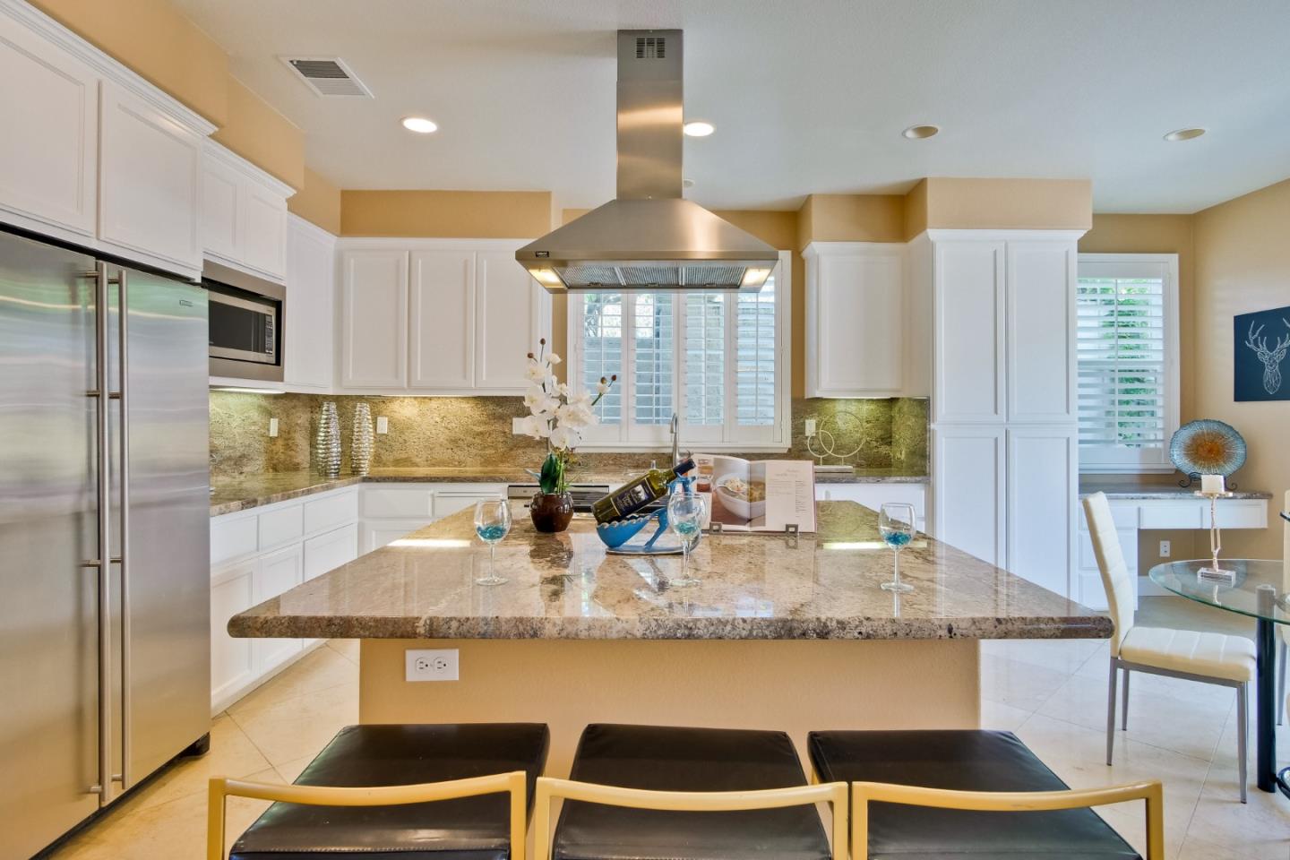 801 Pipers Brook Court San Ramon, CA 94582 - Photo 30 of 78 a kitchen with kitchen island granite countertop a table chairs and a refrigerator