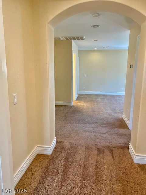 159 Tall Ruff Drive Las Vegas, NV 89148 - Photo 14 of 31 An arched doorway opens to a long hallway with recessed lighting and neutral carpeting.