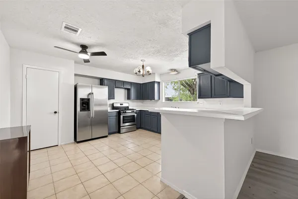 a kitchen with stainless steel appliances granite countertop a refrigerator a sink a stove a microwave a counter top space and cabinets