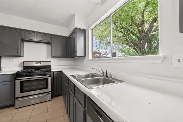 a kitchen with stainless steel appliances granite countertop a sink and a refrigerator