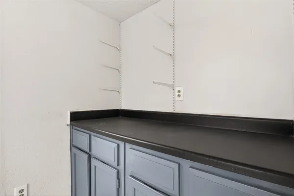 an empty room with wooden floor chandelier fan and windows