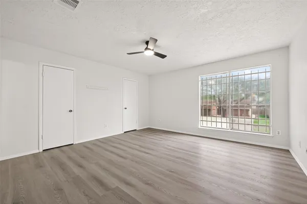 a view of room with hardwood floor and ceiling fan