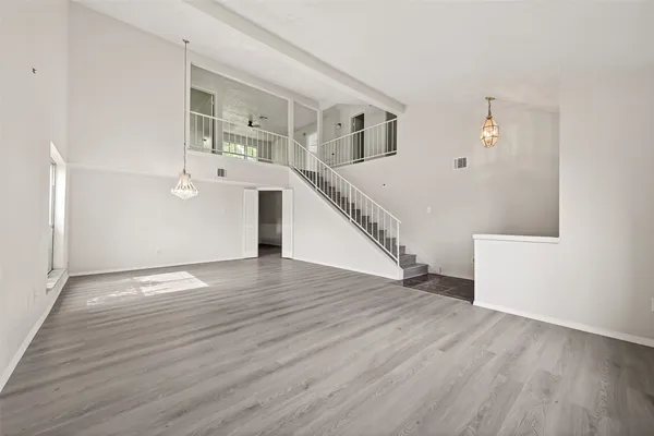 a view of empty room with wooden floor and window