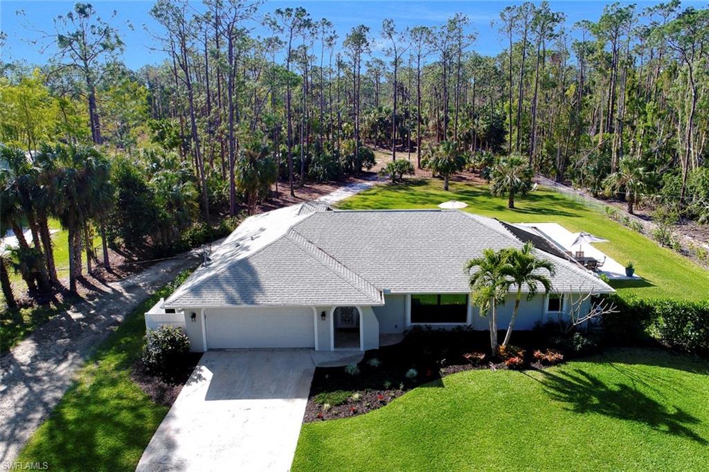 an aerial view of a house with swimming pool a yard and a patio