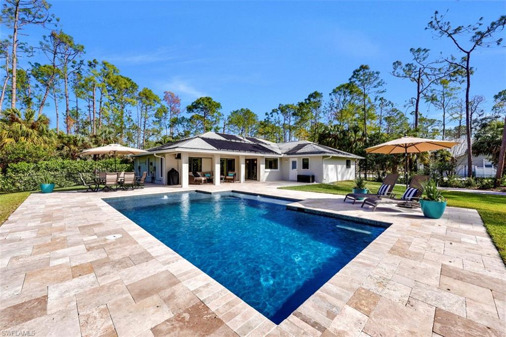 5260 Mahogany Ridge Drive Naples, FL 34119 - Photo 2 of 15 swimming pool view with a seating space and a garden view