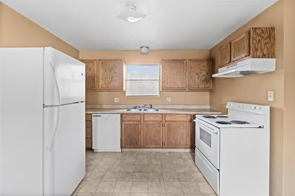 a kitchen with a stove a refrigerator and a sink