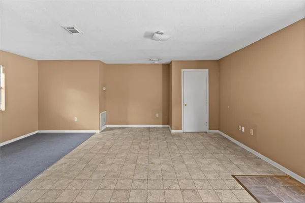a view of an empty room with window and closet area