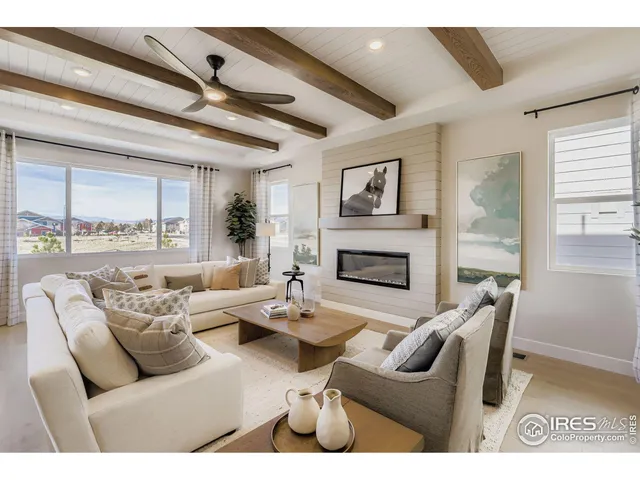 a living room with furniture a large window and a fireplace