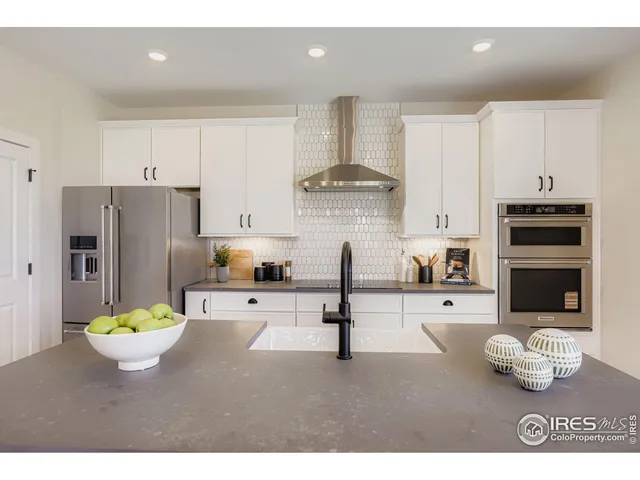 a kitchen with stainless steel appliances kitchen island granite countertop a refrigerator and a stove top oven
