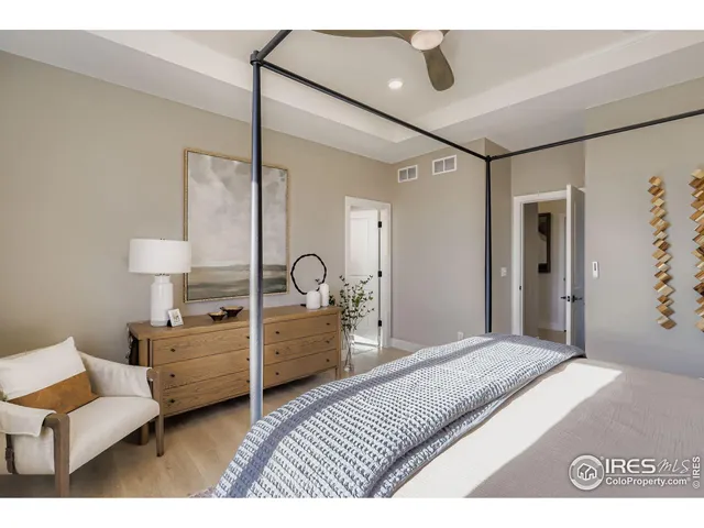 a bedroom with a large bed and windows