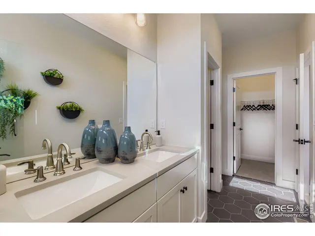 a bathroom with a granite countertop sink a mirror and shower