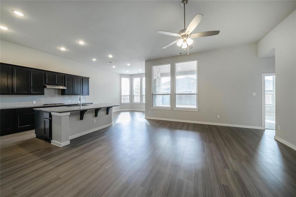 1113 Sheldon Drive Anna, TX 75409 - Photo 12 of 35 a large kitchen with stainless steel appliances granite countertop a large counter top a wooden floors and a view of living room