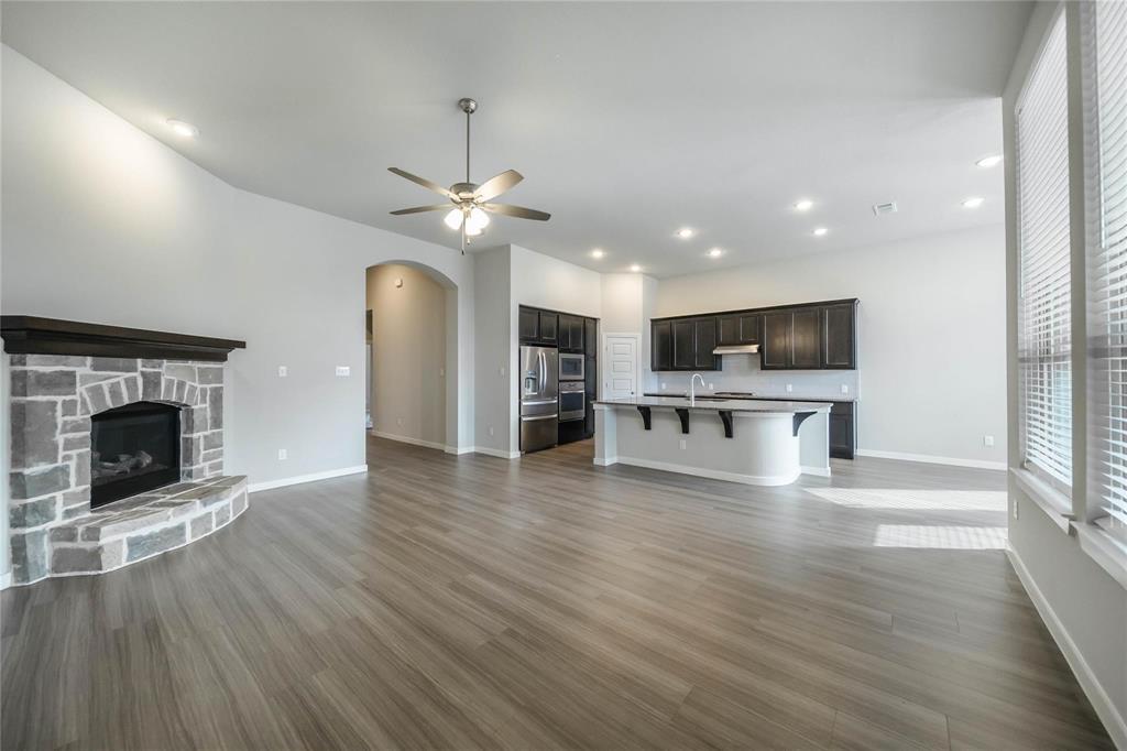 1113 Sheldon Drive Anna, TX 75409 - Photo 13 of 35 a view of a kitchen with a fireplace wooden floor and windows
