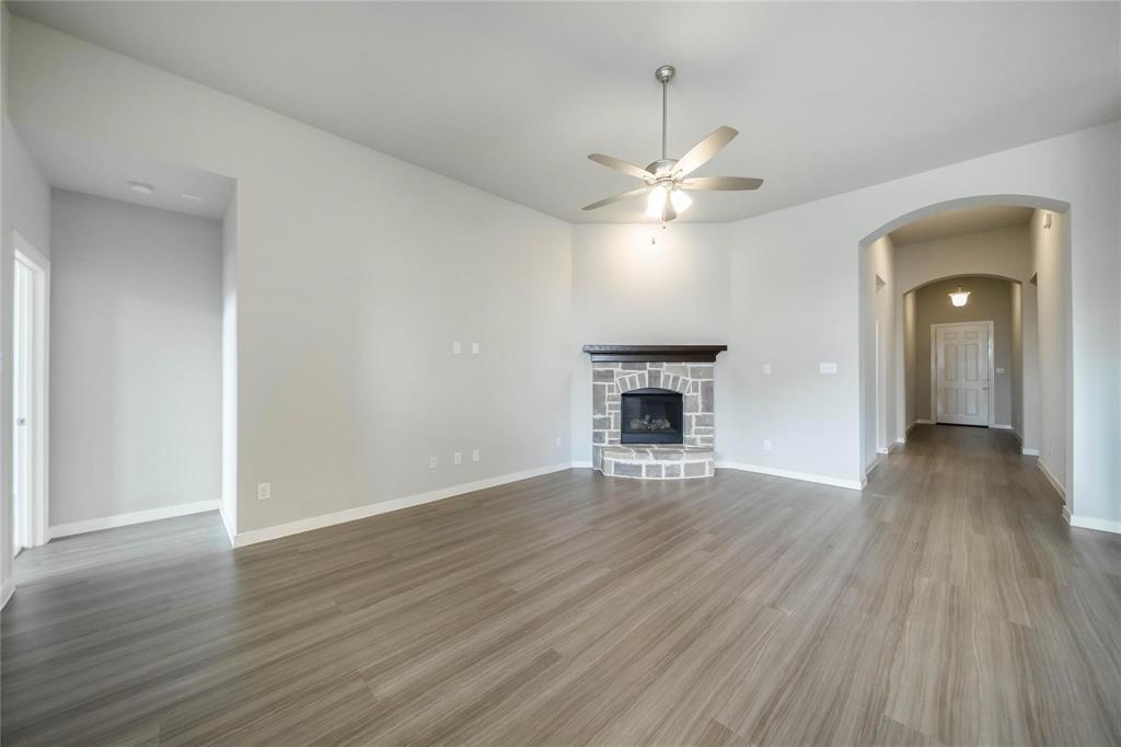 1113 Sheldon Drive Anna, TX 75409 - Photo 14 of 35 an empty room with wooden floor chandelier fan and windows