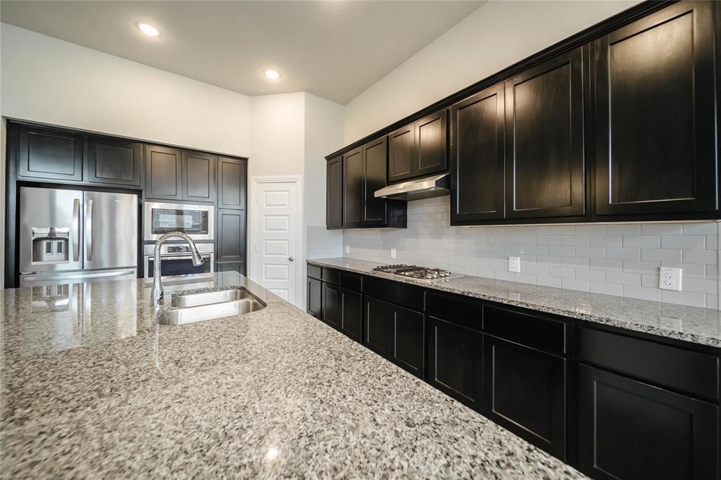 1113 Sheldon Drive Anna, TX 75409 - Photo 18 of 35 a large kitchen with stainless steel appliances wooden cabinets a stove and a sink