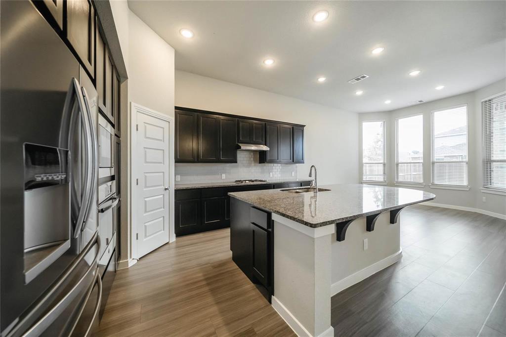 1113 Sheldon Drive Anna, TX 75409 - Photo 19 of 35 a kitchen with kitchen island granite countertop stainless steel appliances and sink