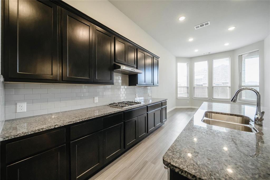 1113 Sheldon Drive Anna, TX 75409 - Photo 20 of 35 a kitchen with stainless steel appliances granite countertop wooden cabinets a sink and dishwasher