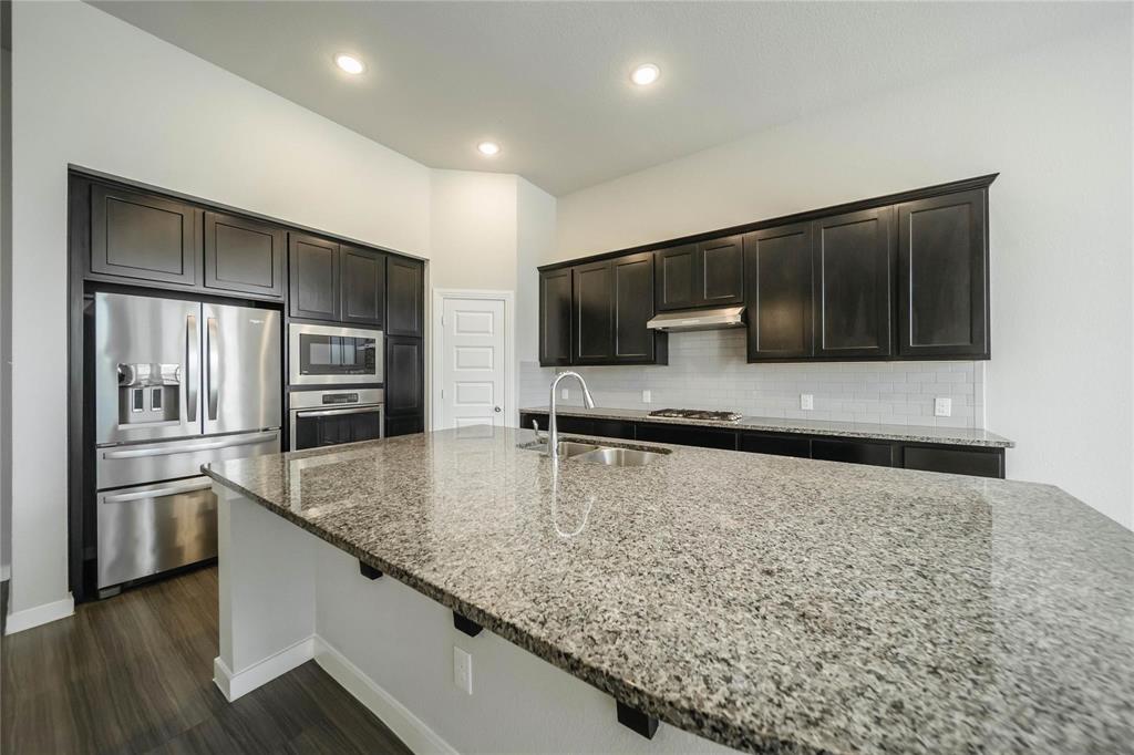 1113 Sheldon Drive Anna, TX 75409 - Photo 21 of 35 a kitchen with stainless steel appliances granite countertop a sink and a microwave
