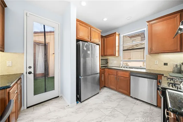 a kitchen with stainless steel appliances granite countertop a stove a sink and a microwave