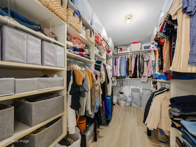 a view of walk in closet with clothes and shoes