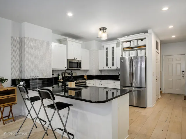 a kitchen with stainless steel appliances granite countertop a refrigerator and a stove top oven