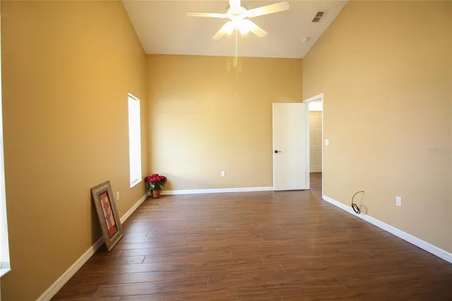 a view of an empty room with wooden floor