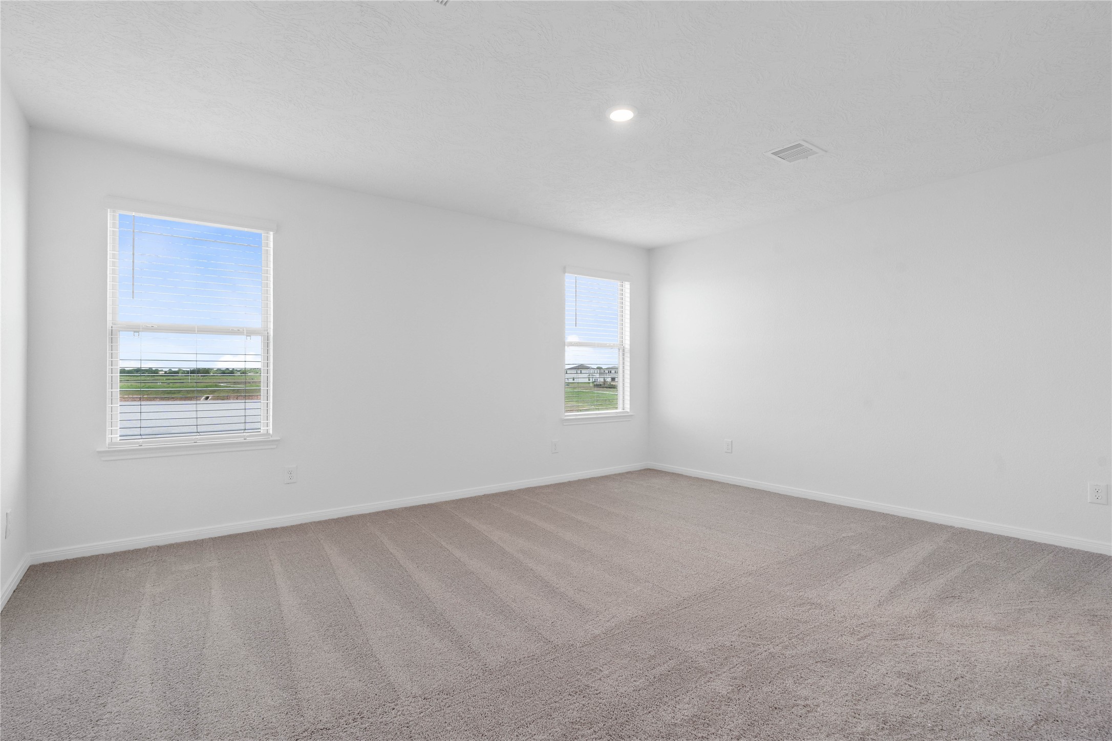 7210 Brooklea Road Beasley, TX 77417 - Photo 19 of 32 Relax and recharge in this stunning primary suite! Enjoy the comfort of plush carpeting, neutral-toned walls, high ceilings, recessed lighting, and large windows with fitted blinds that fill the room with natural light.