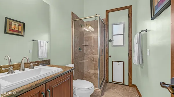 a bathroom with a granite countertop sink toilet and shower