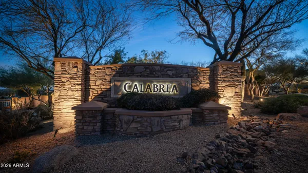 a sign board with a house in the background