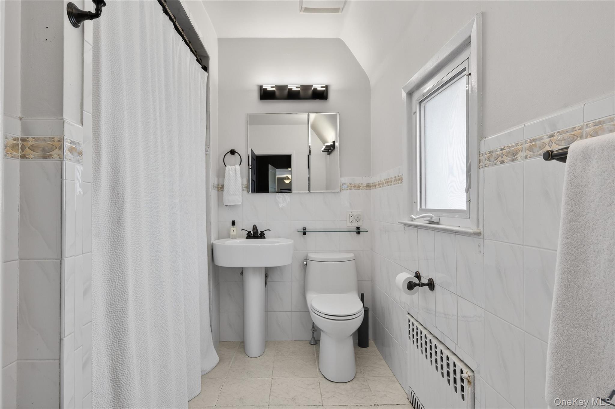 3 Beacon Hill Road Port Washington, NY 11050 - Photo 21 of 43 a bathroom with a toilet a sink and a mirror