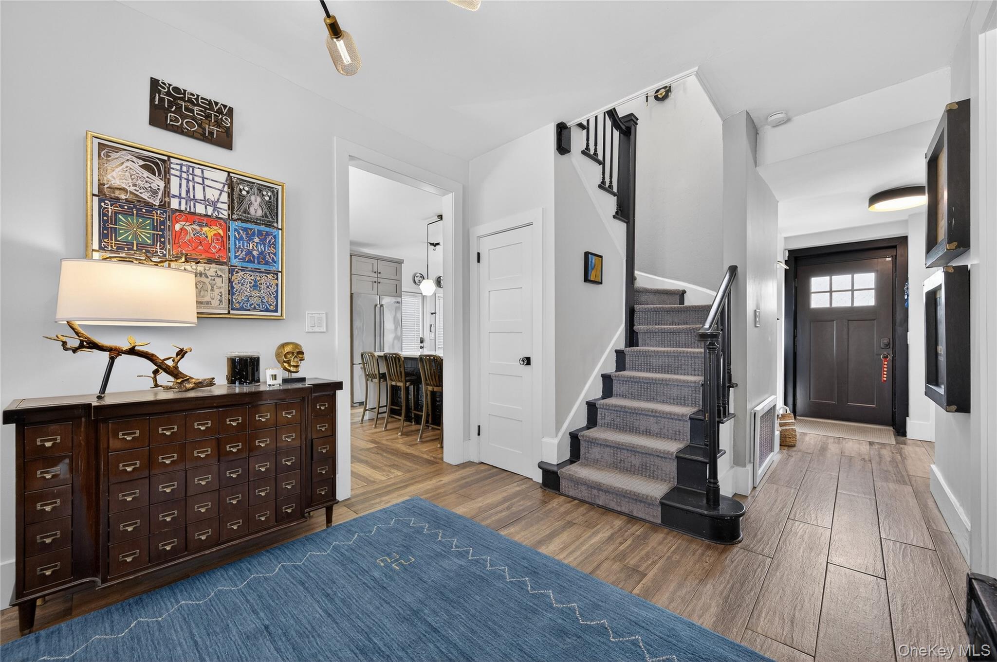 3 Beacon Hill Road Port Washington, NY 11050 - Photo 4 of 43 a view of a living room and entryway with wooden floor