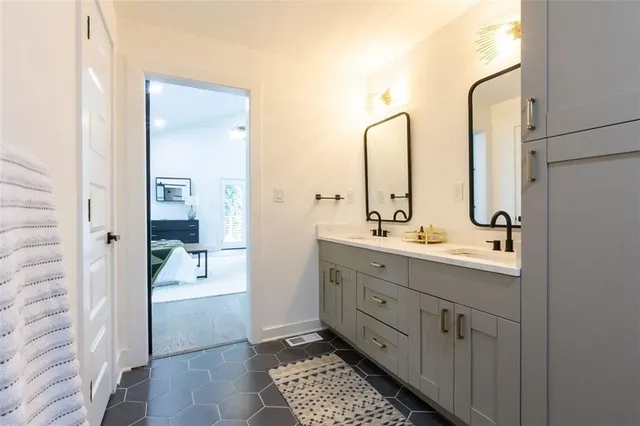 a en suite bathroom with a double vanity sink a mirror and a shower