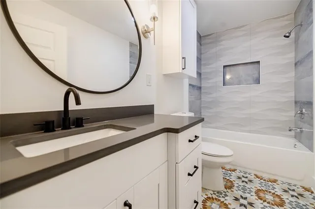 a bathroom with a sink a toilet and a mirror